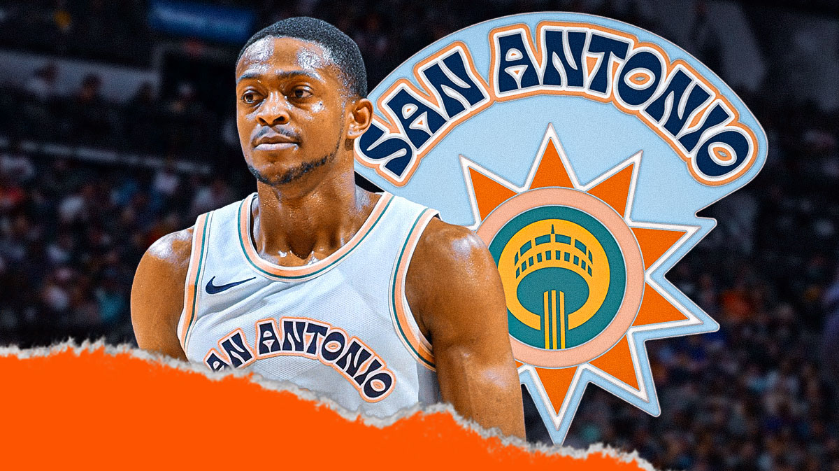 De'Aaron Fox looking serious, close-up image. San Antonio Spurs 2024-25 logo in background in front of Frost Bank Center.
