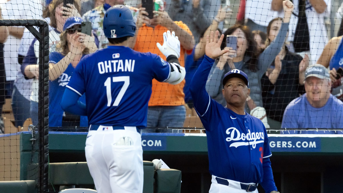 Los Angeles Dodgers designated hitter Shohei Ohtani (17) celebrates with manager Dave Roberts after hitting a home run against the Los Angeles Angels during a spring training game at Camelback Ranch-Glendale. 