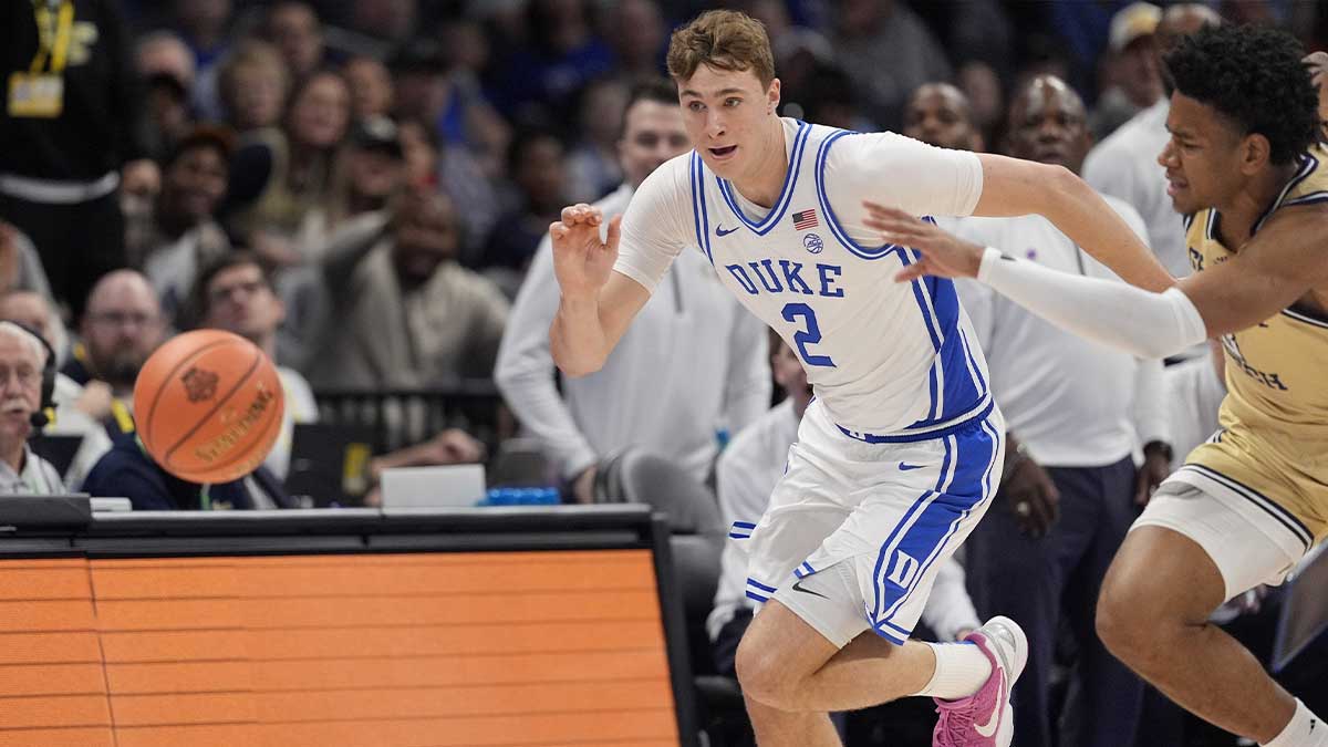 Duke Blue Devils forward Cooper Flagg (2) and Georgia Tech Yellow Jackets guard Jaeden Mustaf (3) chase the loose ball during the first half at Spectrum Center.