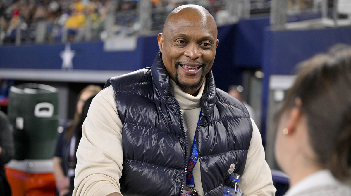 Former NFL player Eddie George signs a football for the fans during the second half of the game between the East and the West at AT&T Stadium.