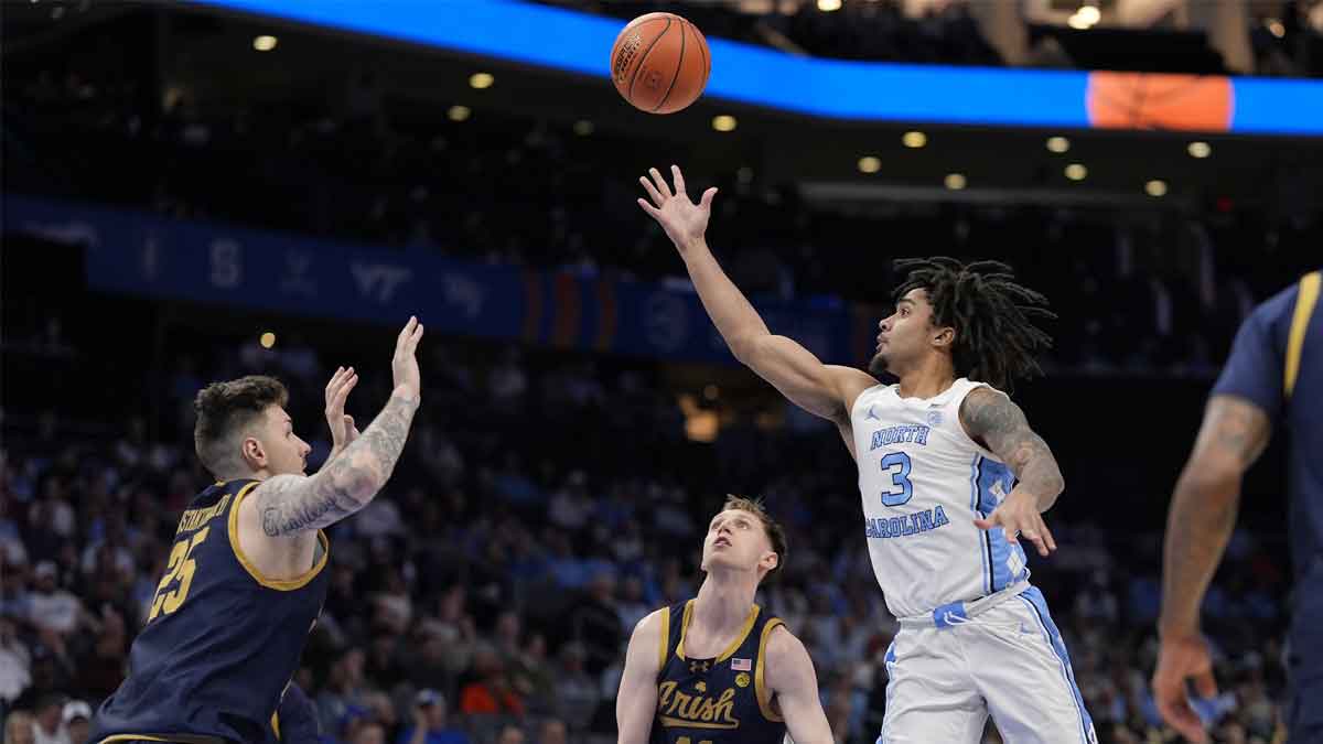 North Carolina Tar Heels guard Elliot Cadeau (3) tosses the ball up for a pass to dunk combo against the Notre Dame Fighting Irish during the second half at Spectrum Center.