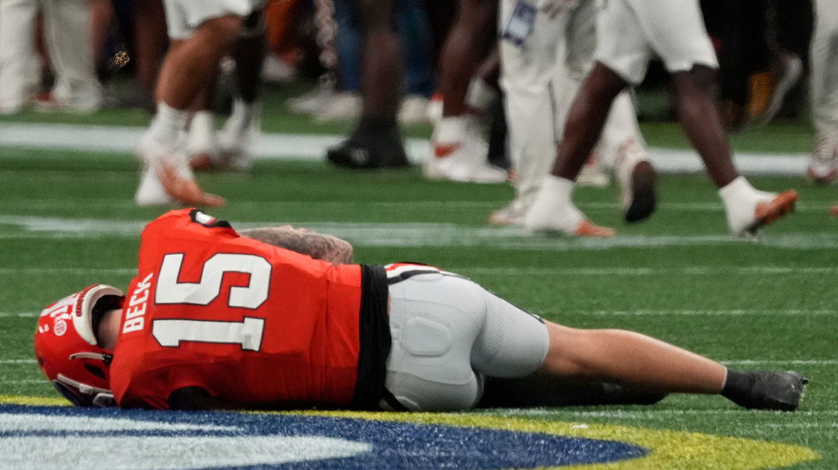 Georgia quarterback Carson Beck (15) goes down after a hit on this trowing shoulder during the first half of the SEC championship game against Texas in Atlanta, on Saturday, Dec. 7, 2024.