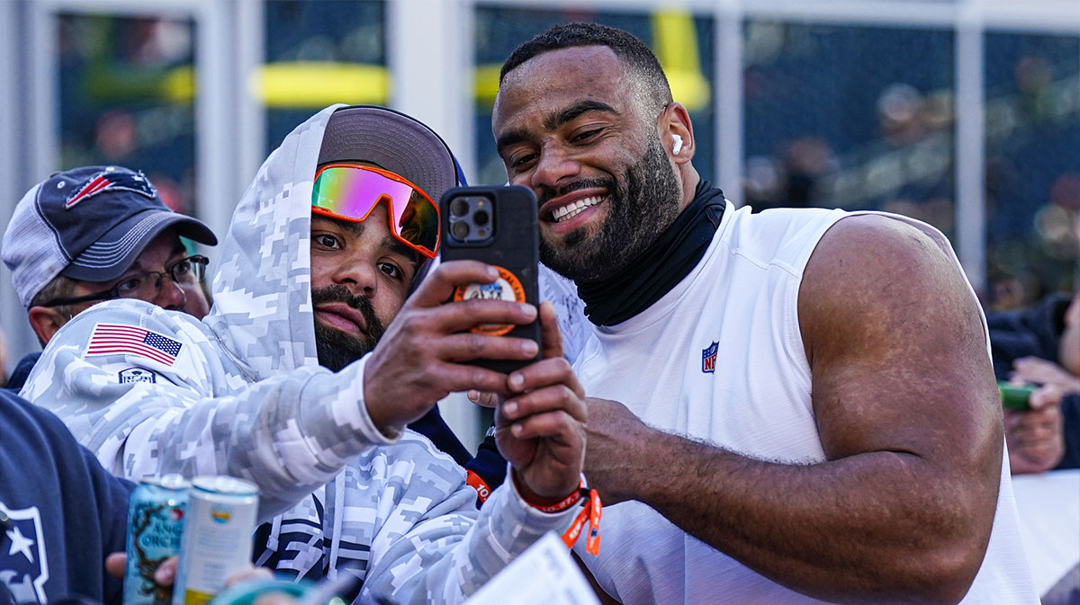 New York Jets defensive end Solomon Thomas (94) takes a selfie with a fan before the start of the game against the New England Patriots at Gillette Stadium.