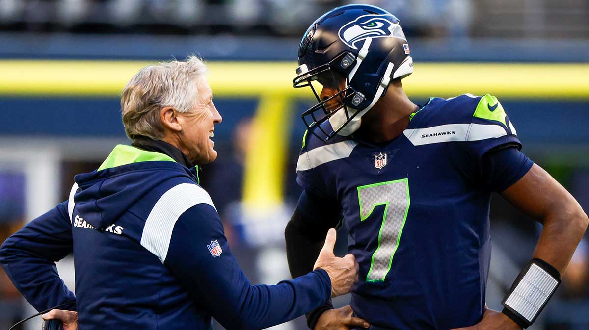 Seattle Seahawks head coach Pete Carroll, left, talks with quarterback Geno Smith (7) during a fourth quarter timeout against the New York Jets at Lumen Field.