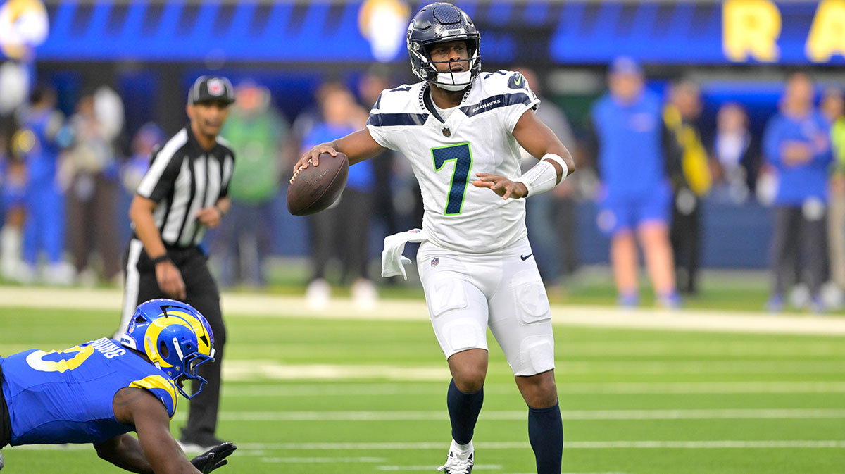 Seattle Seahawks quarterback Geno Smith (7) scrambles away from Los Angeles Rams linebacker Byron Young (0) and throws for a touchdown in the first half at SoFi Stadium. 