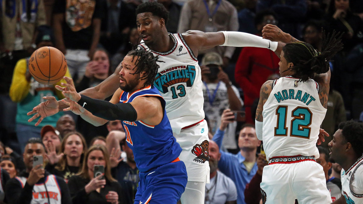 New York Knicks guard Jalen Brunson (11) passes the ball between Memphis Grizzlies forward Jaren Jackson Jr. (13) and guard Ja Morant (12) during the fourth quarter at FedExForum.