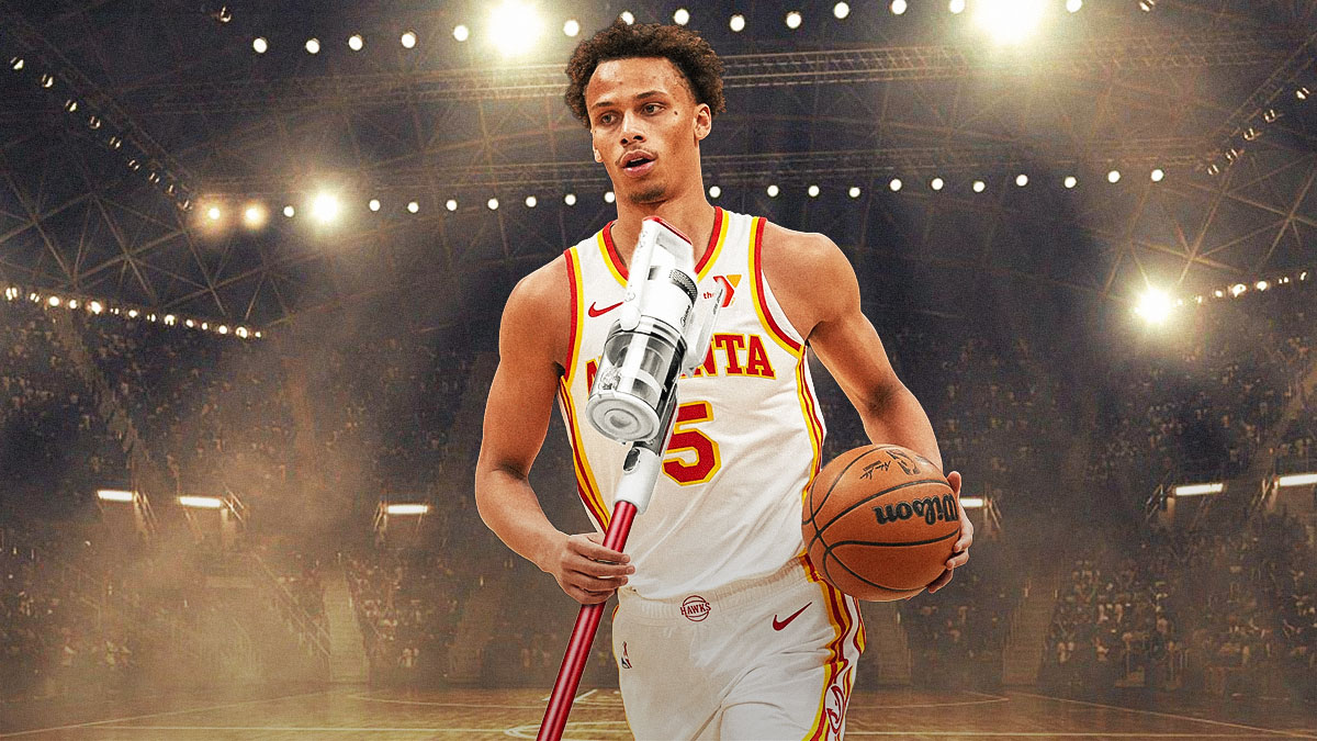 Hawks' Dyson Daniels holding a vacuum cleaner