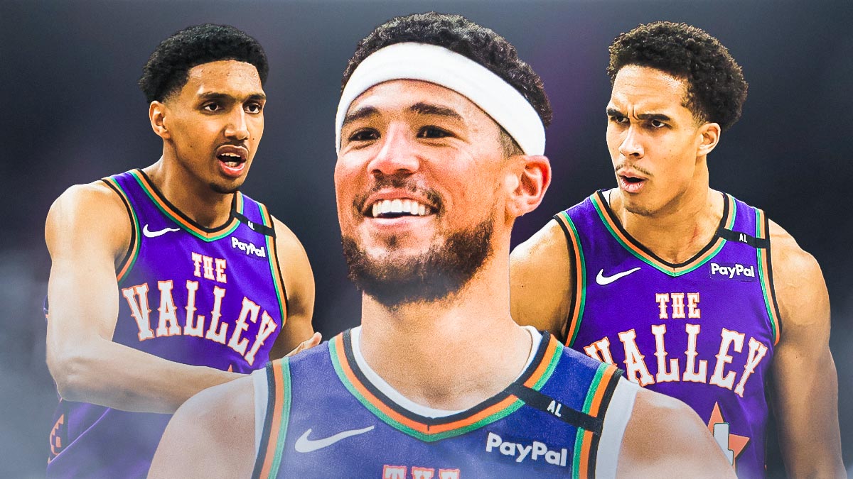 Devin Booker smiling, with Suns rookie Oso Ighodaro and Ryan Dunn looking hyped beside him.