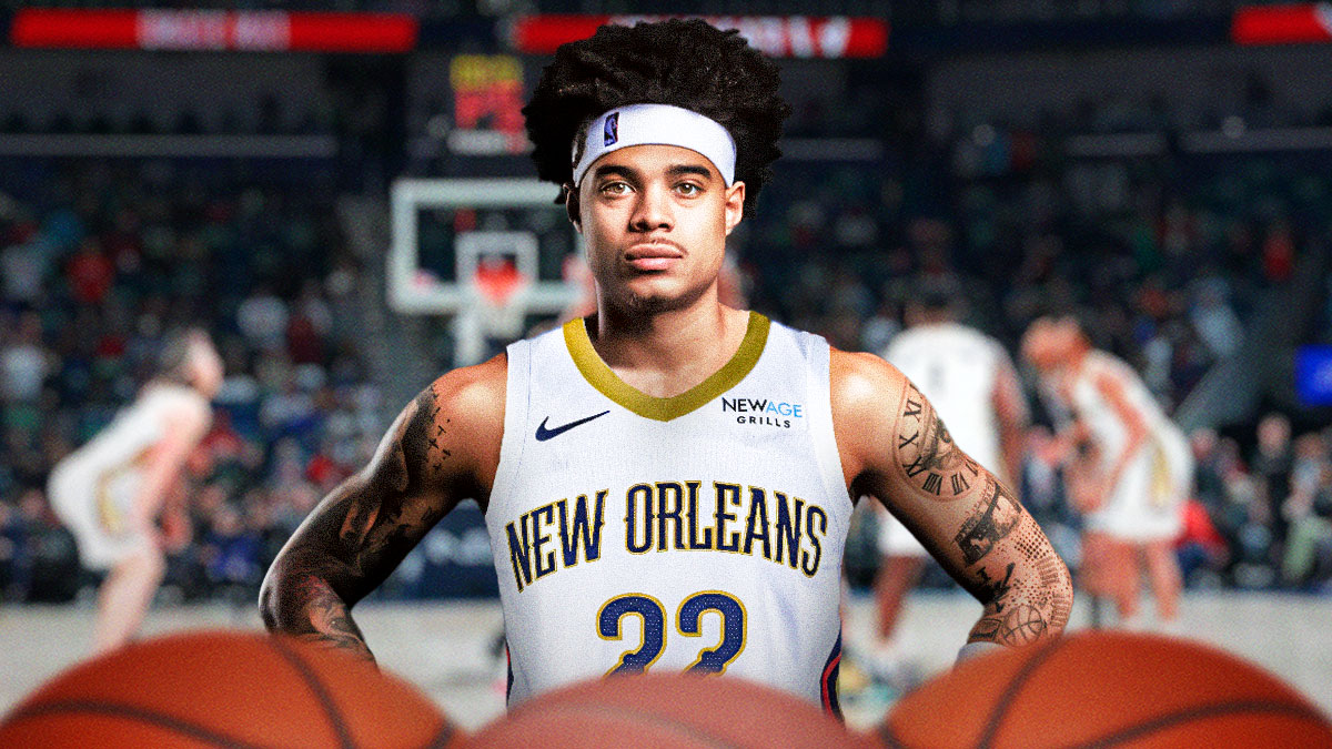 NBA player Lester Quinones in a New Orleans Pelicans jersey with the Pelicans arena in the background, roster signing