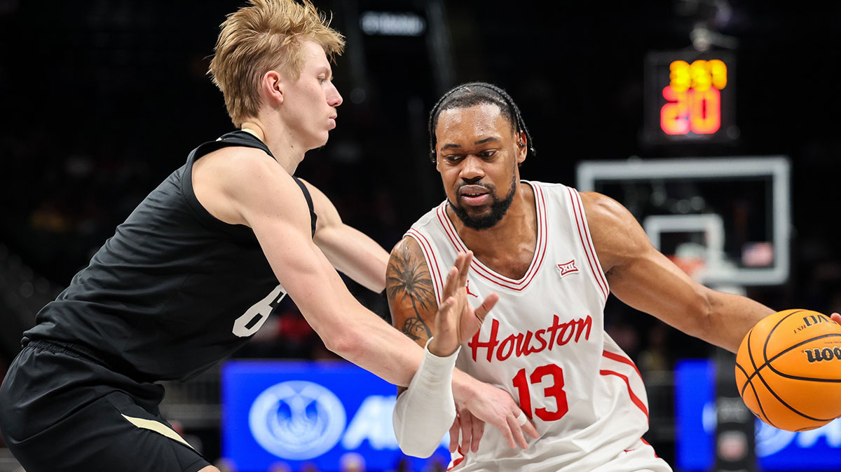 Houston Cougars forward J'Wan Roberts (13) drives to the basket around Colorado Buffaloes forward Trevor Baskin (6) during the first half at T-Mobile Center.