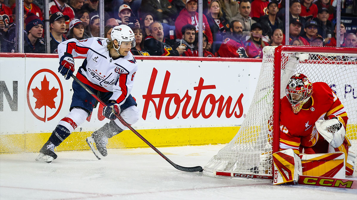 Washington Capitals defenseman Jakob Chychrun (6) controls the puck behind the net of the Calgary Flames goaltender Dustin Wolf (32) during the third period at Scotiabank Saddledome.
