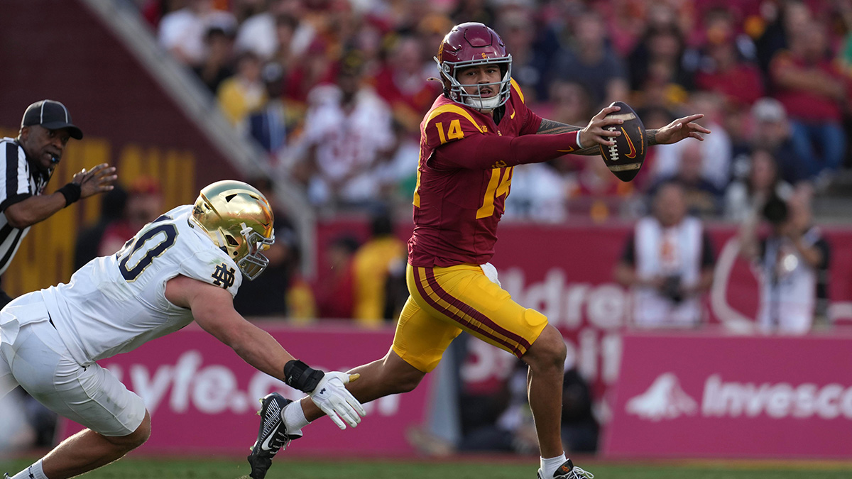 Southern California Trojans quarterback Jayden Maiava (14) carries the ball against Notre Dame Fighting Irish defensive lineman Joshua Burnham (40) in the second half at United Airlines Field at Los Angeles Memorial Coliseum. Mandatory Credit: Kirby Lee-Imagn Images