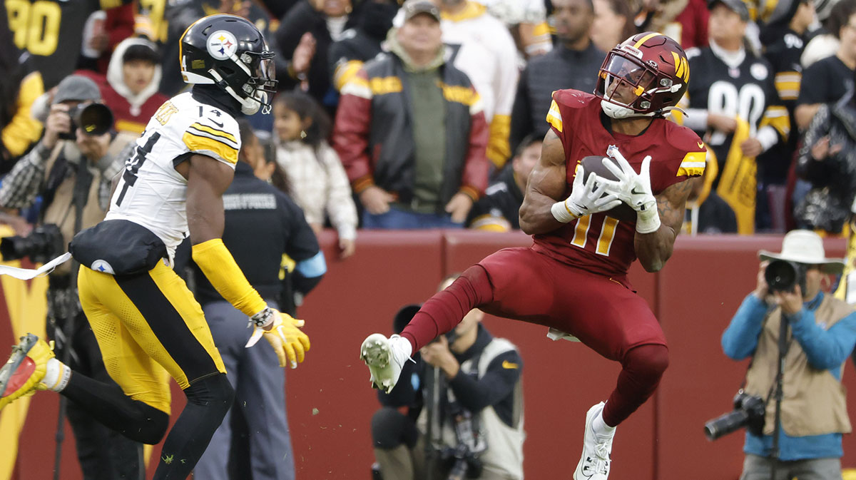 Nov 10, 2024; Landover, Maryland, USA; Washington Commanders safety Jeremy Chinn (11) intercepts a pass intended for Pittsburgh Steelers wide receiver George Pickens (14) during the second half at Northwest Stadium. 