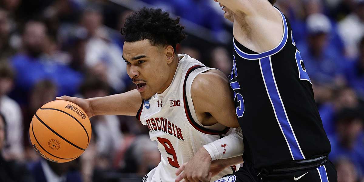 Wisconsin Badgers guard John Tonje (9) dribbles the ball past Brigham Young Cougars guard Dawson Baker (25) during the first half in the second round of the NCAA Tournament at Ball Arena.