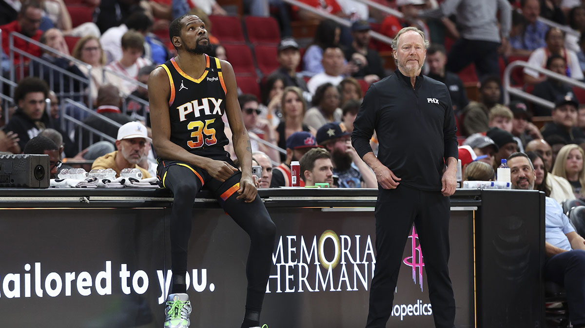 Phoenix Suns forward Kevin Durant (35) sits on the scorers table as head coach Mike Budenholzer looks on during the second quarter against the Houston Rockets at Toyota Center.