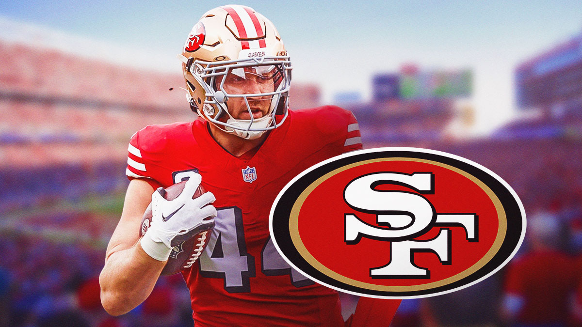 Kyle Juszczyk playing football with the 49ers logo next to him