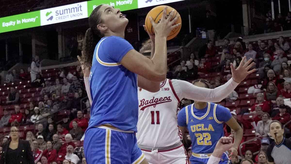 UCLA center Lauren Betts (51) scores as Wisconsin forward Alie Bisballe (2) stumbles during the first half Wednesday at the Kohl Center in Madison.