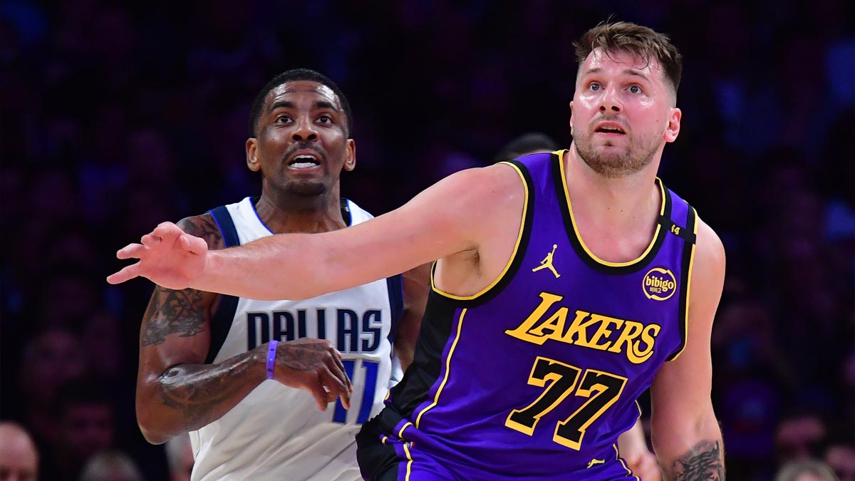 25. February 2025; Los Angeles, California, USA; Los Angeles Lakers Guard Luka Doncic (77) and Dallas Mavericks Guard Kirie Irving (11) try to get control during the first quarter at the CRIPTO.com Arena.