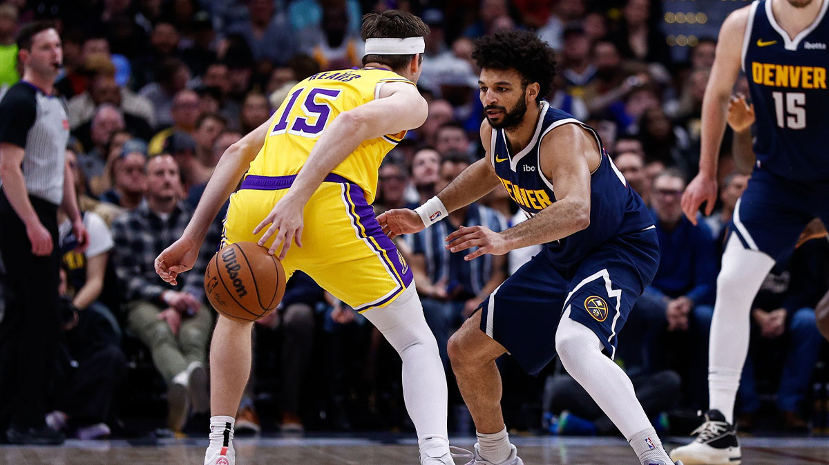 Los Angeles Lakers guard Austin Reaves (15) controls the ball as Denver Nuggets guard Jamal Murray (27) guards in the second quarter at Ball Arena.