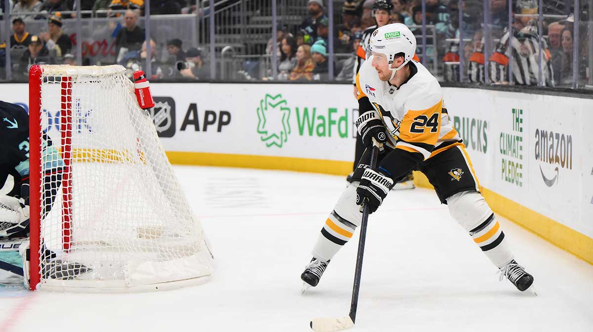 Pittsburgh Penguins defenseman Matt Grzelcyk (24) plays the puck during the second period against the Seattle Kraken at Climate Pledge Arena