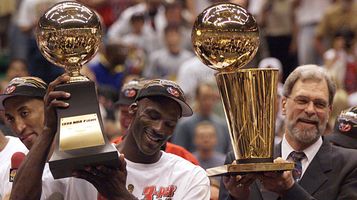 Chicago Bulls guard Michael Jordan holds the MVP trophy and coach Phil Jackson holds the championship trophy after the Bulls beat the Utah Jazz to win their 6th NBA title.