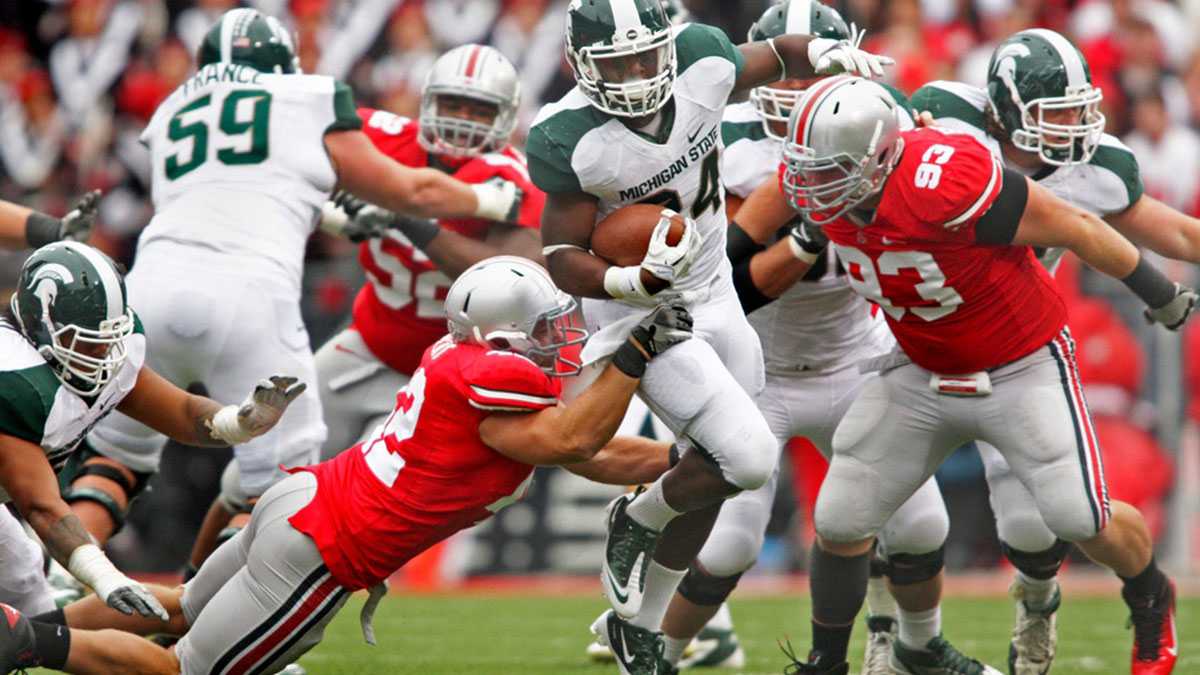 Michigan State Spartans running back Le'Veon Bell (24) runs past Ohio State Buckeyes linebacker Andrew Sweat (42) and Ohio State Buckeyes defensive tackle Adam Bellamy (93) in their NCAA College football game at Ohio Stadium, October 1, 2011.