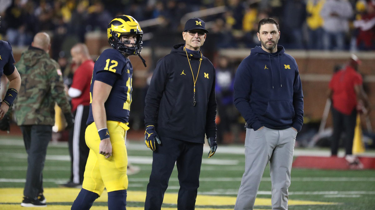 Michigan Wolverines head coach Jim Harbaugh, center, quarterbacks coach Matt Weiss, right, and quarterback Cade McNamara during warmups before action against the Indiana Hoosiers