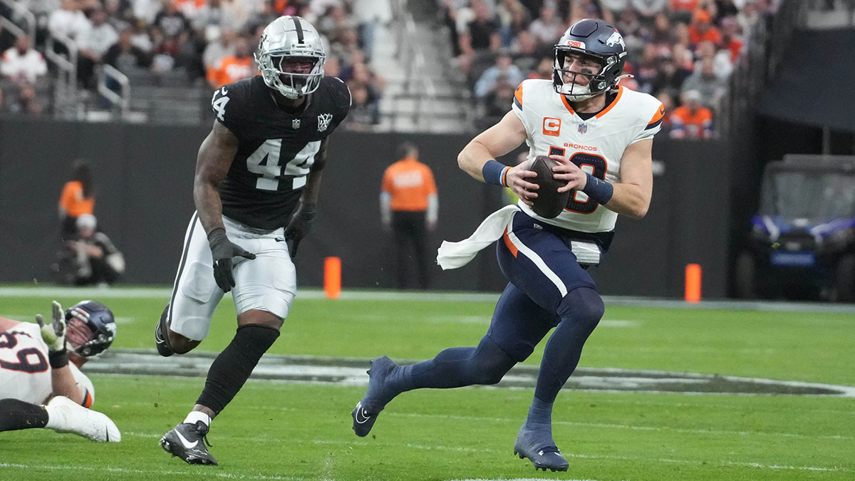 Nov 24, 2024; Paradise, Nevada, USA; Denver Broncos quarterback Bo Nix (10) carries the ball against Las Vegas Raiders defensive end K'Lavon Chaisson (44) in the second quarter at Allegiant Stadium. 