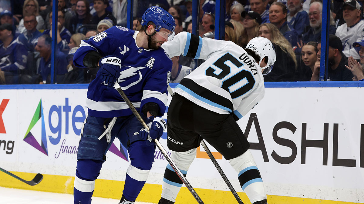 Tampa Bay Lightning right wing Nikita Kucherov (86) and Utah Hockey Club defensemen Sean Durzi (50) fight to control the puck during the first period at Amalie Arena.
