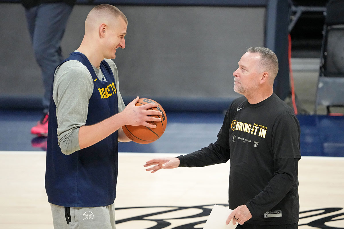 Denver Nuggets center Nikola Jokic (15) talks with head coach Michael Malone during a practice session on media day before the 2023 NBA Finals at Ball Arena. 