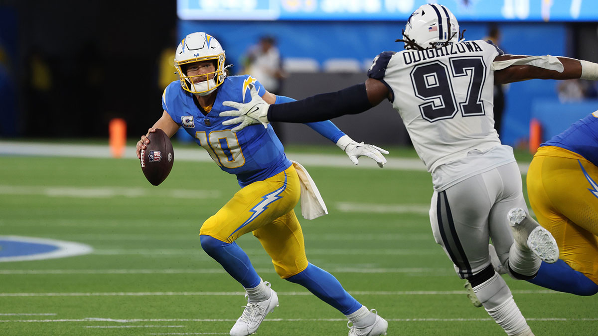 Oct 16, 2023; Inglewood, California, USA; Los Angeles Chargers quarterback Justin Herbert (10) runs away from Dallas Cowboys defensive tackle Osa Odighizuwa (97) during the third quarter at SoFi Stadium. 