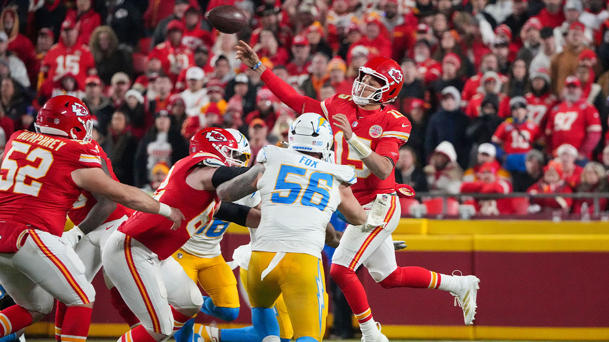 Kansas City Chiefs quarterback Patrick Mahomes (15) leaps while passing as Los Angeles Chargers defensive end Morgan Fox (56) defends during the second half at GEHA Field at Arrowhead Stadium.