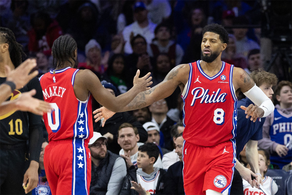 Philadelphia 76ers forward Paul George (8) high fives guard Tyrese Maxey (0) after scoring during the fourth quarter against the Cleveland Cavaliers at Wells Fargo Center.