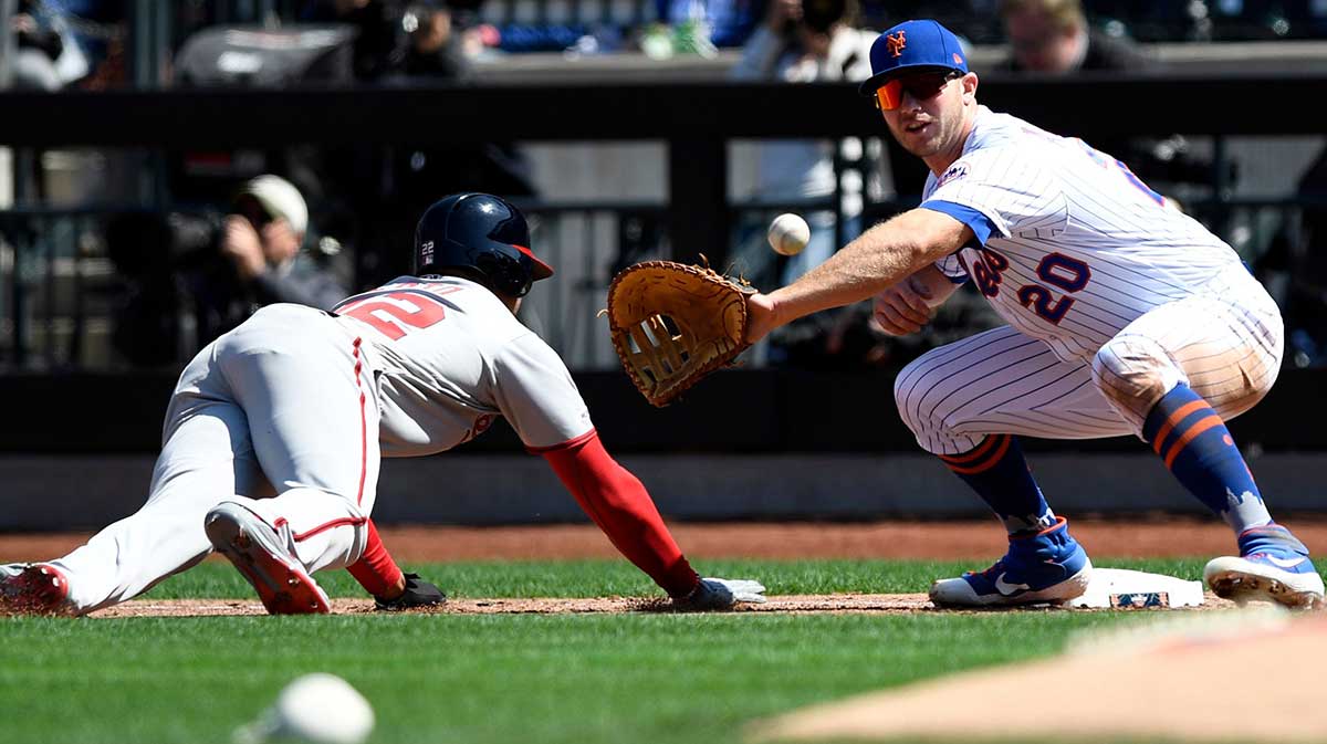 Washington Nationals runner Juan Soto slides back to first before New York Mets first baseman Pete Alonso (20) can place the tag during the Mets home opener against the Washington Nationals on Thursday, April 4, 2019, in Flushing, NY. Mets Home Opener