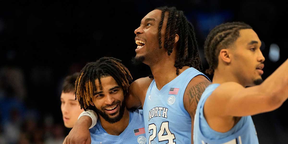 North Carolina Tar Heels head coach Hubert Davis talks with guard RJ Davis (4) as forward Jae'Lyn Withers (24) looks on in the second half at Spectrum Center.