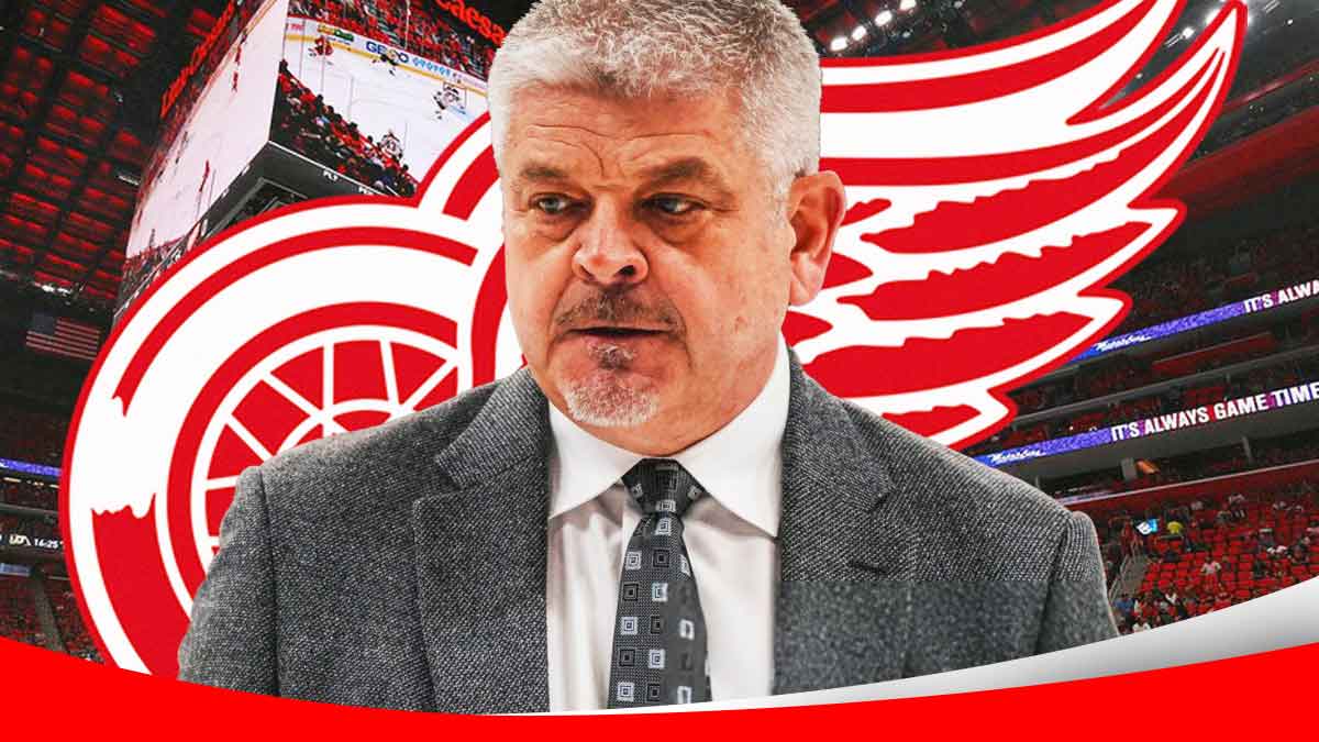 Red Wings coach Todd McLellan in front of the logo at Little Caesars Arena.