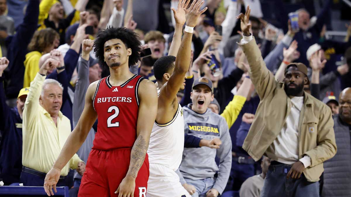 Rutgers Scarlet Knights guard Dylan Harper (2) reacts as Michigan Wolverines guard Nimari Burnett (4) and Detroit Pistons forward Tim Hardaway Jr. (right) celebrate after Nimari Burnett makes a buzzer beater three point shot to win the game at the end of the second half at Crisler Center.