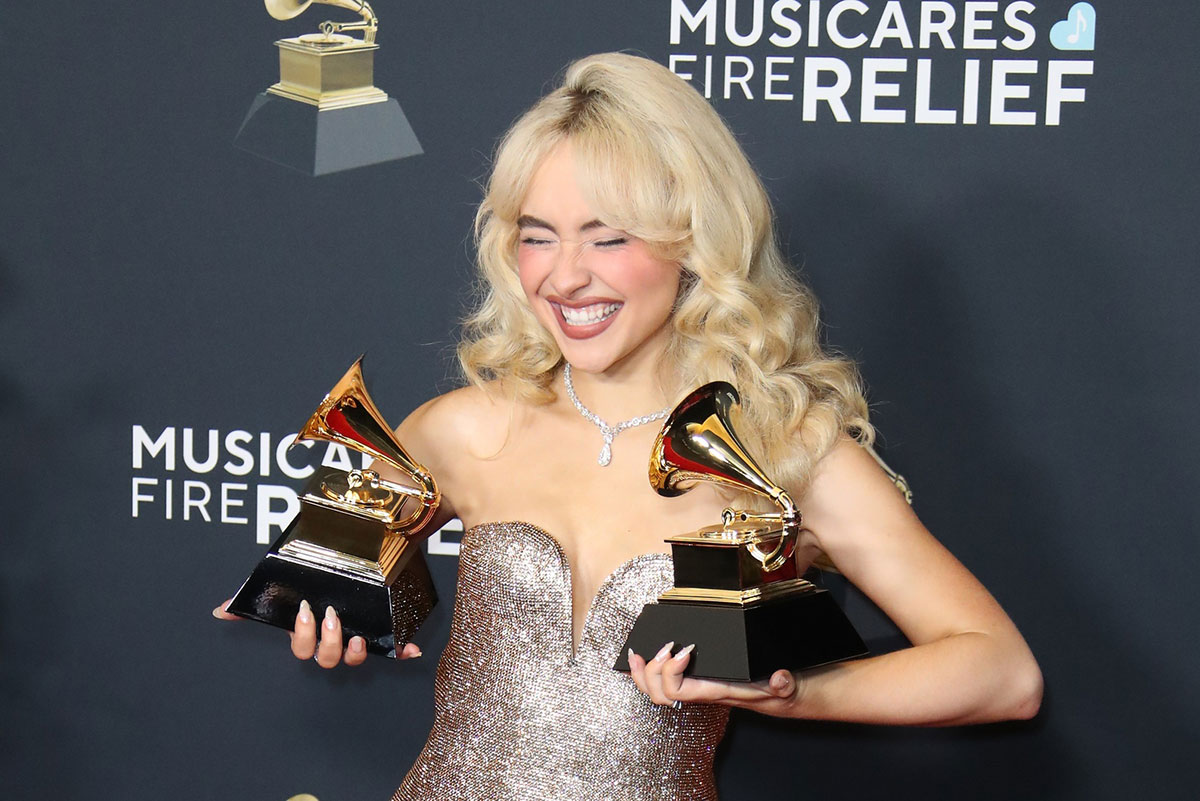 Sabrina Carpenter at the Grammys on February 2, 2025, holding two trophies.