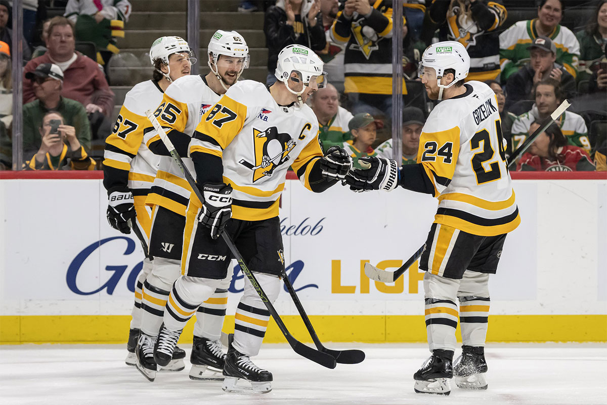 Pittsburgh Penguins forward Sidney Crosby (87) celebrates his empty net goal against the Minnesota Wild with forward Rickard Rakell (67), defenseman Erik Karlsson (65, and defenseman Matt Grzelcyk (24) during the third period at Xcel Energy Center.