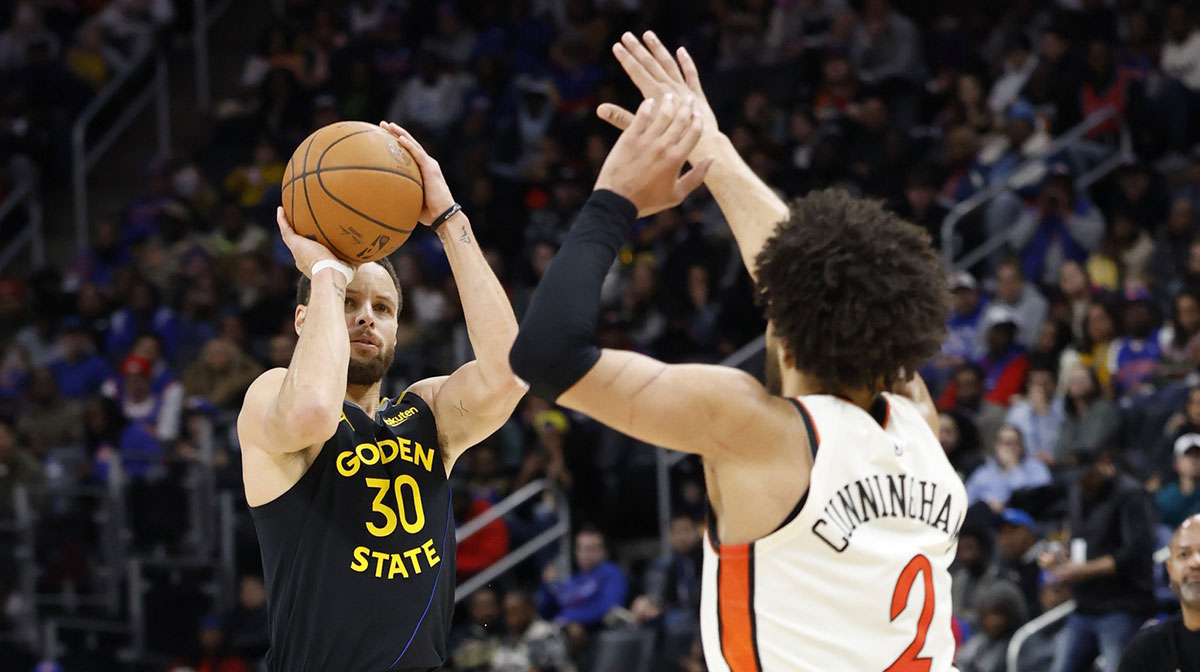 Golden State Warriors guard Stephen Curry (30) shoots against Detroit Pistons guard Cade Cunningham (2) in the second half at Little Caesars Arena.