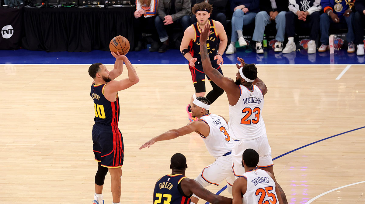 Golden State Warriors guard Stephen Curry (30) shoots a three point shot against New York Knicks guard Josh Hart (3) and center Mitchell Robinson (23) during the first quarter at Madison Square Garden. 