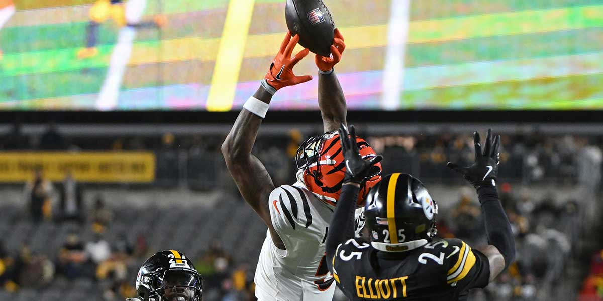 Cincinnati Bengals wide receiver Tee Higgins (5) catches a pass in front of Pittsburgh Steelers cornerback Joey Porter Jr. (24) and safety DeShon Elliott (25) during the second quarter at Acrisure Stadium.