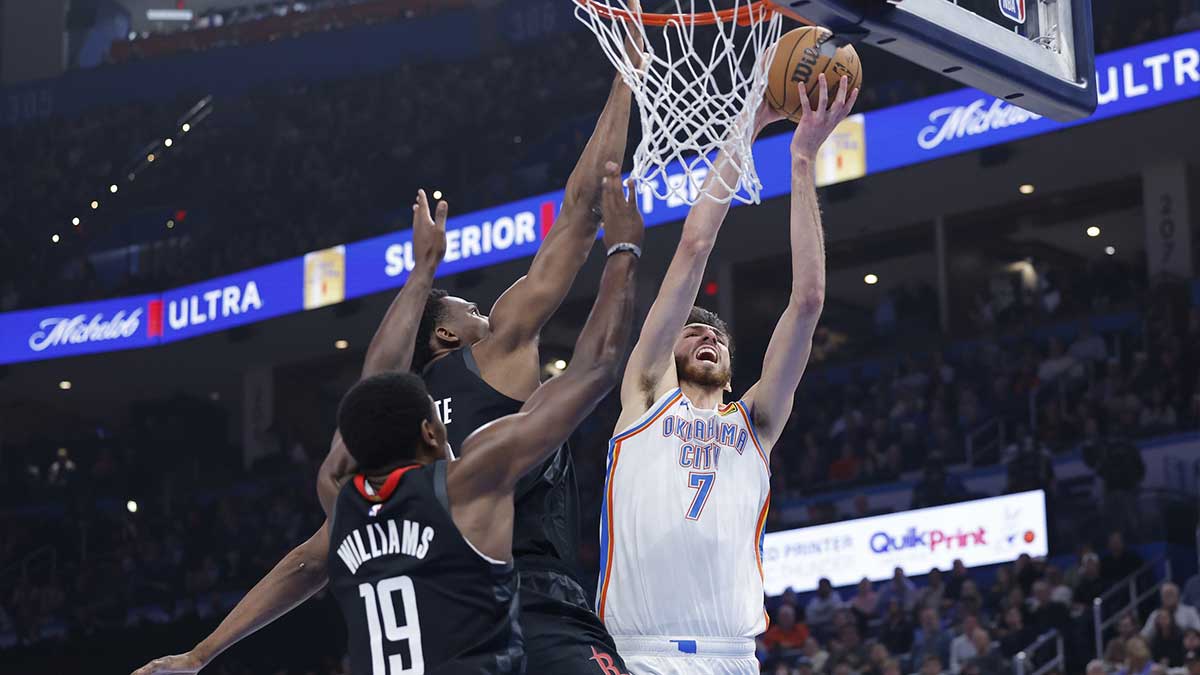 Thunder forward Chet Holmgren (7) is defended by Houston Rockets forward Jae'Sean Tate (8) and guard Nate Williams (19) on the way to the basket during the second quarter at Paycom Center