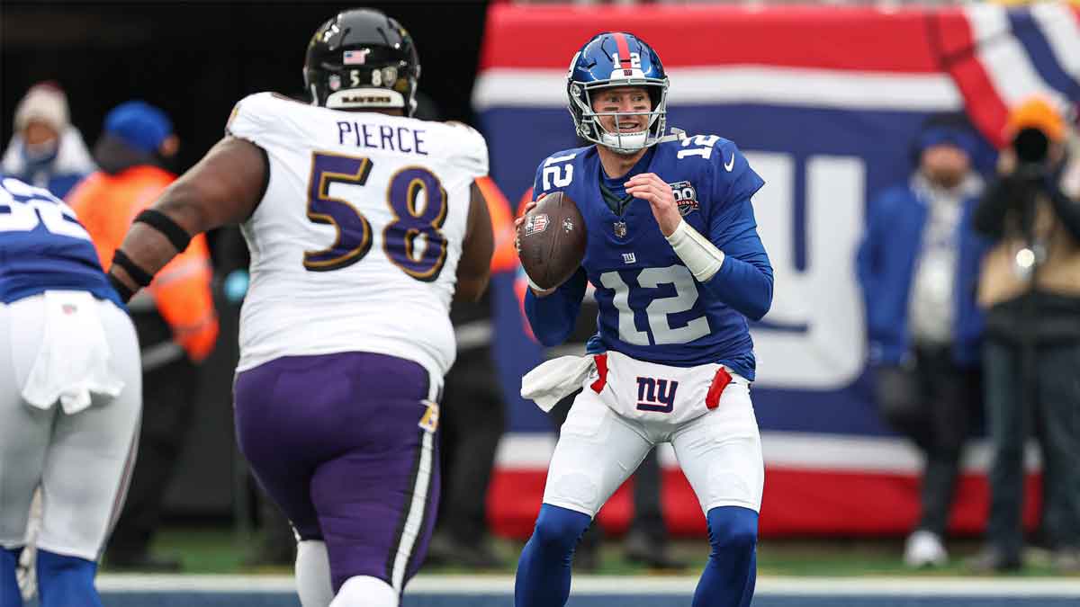 Dec 15, 2024; East Rutherford, New Jersey, USA; New York Giants quarterback Tim Boyle (12) throws the ball as Baltimore Ravens defensive tackle Michael Pierce (58) pursues during the second half at MetLife Stadium.