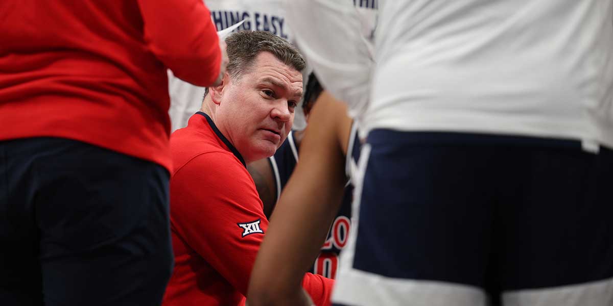 Arizona Wildcats head coach Tommy Lloyd talks to the team during a time out during the first half for the Big 12 Conference Tournament Championship game at T-Mobile Center.