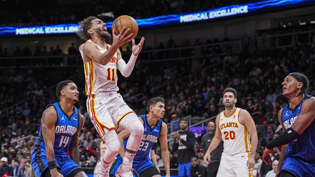 Atlanta Hawks guard Trae Young (11) goes to wards the basket behind Orlando Magic guard Gary Harris (14) during the second half at State Farm Arena.