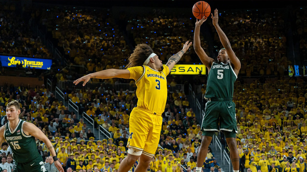 Michigan State player Tre Holloman (5) shoots over Michigan player Tre Donaldson (3) during the first half of their matchup at Crisler Center.