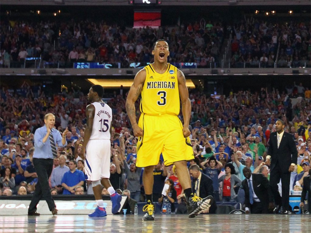 Michigan Wolverines guard Trey Burke (3) reacts after hitting a three-point shot to tie the game with six seconds against the Kansas Jayhawks in the second half during the semifinals of the South regional of the 2013 NCAA Tournament at Cowboys Stadium.