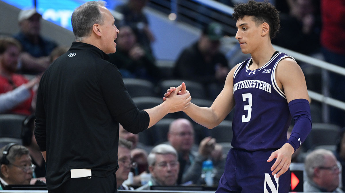 Northwestern Wildcats head coach Chris Collins greets Northwestern Wildcats guard Ty Berry (3) as he checks out of the game during the second half against the Wisconsin Badgers at Gainbridge Fieldhouse.