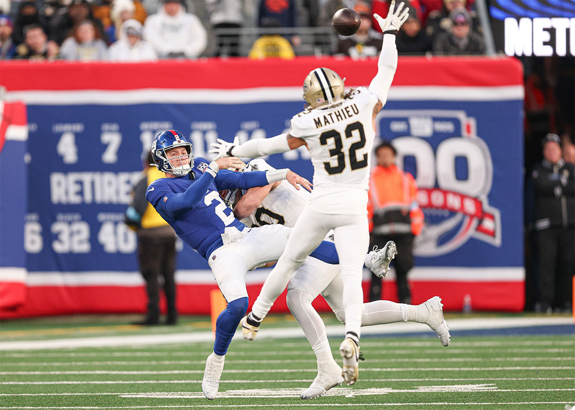 Dec 8, 2024; East Rutherford, New Jersey, USA; New York Giants quarterback Drew Lock (2) throws the ball as New Orleans Saints safety Tyrann Mathieu (32) pursues during the second half at MetLife Stadium.